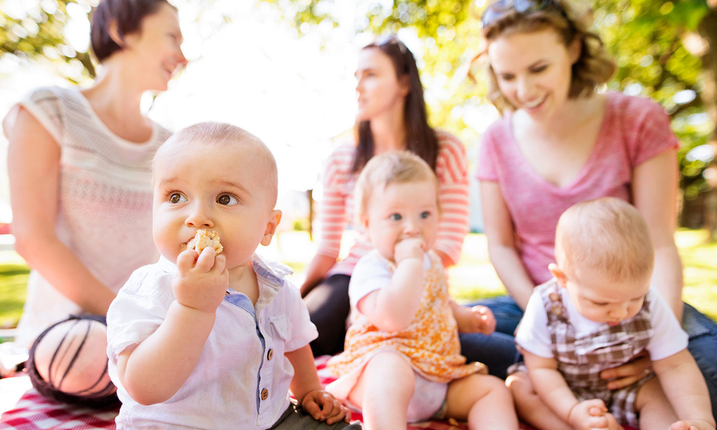Mothers with babies in the background.