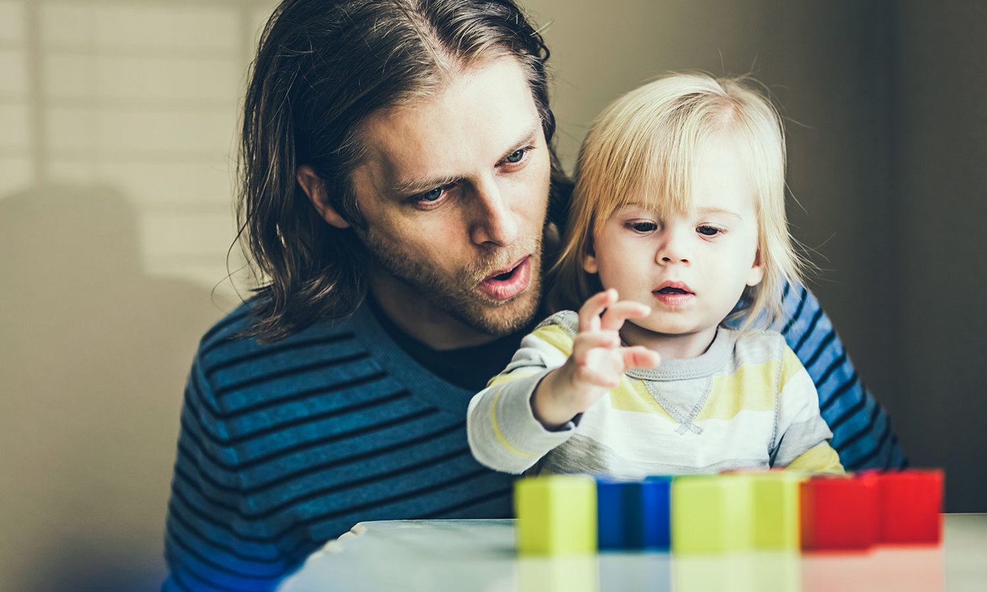 Father and child talking while playing