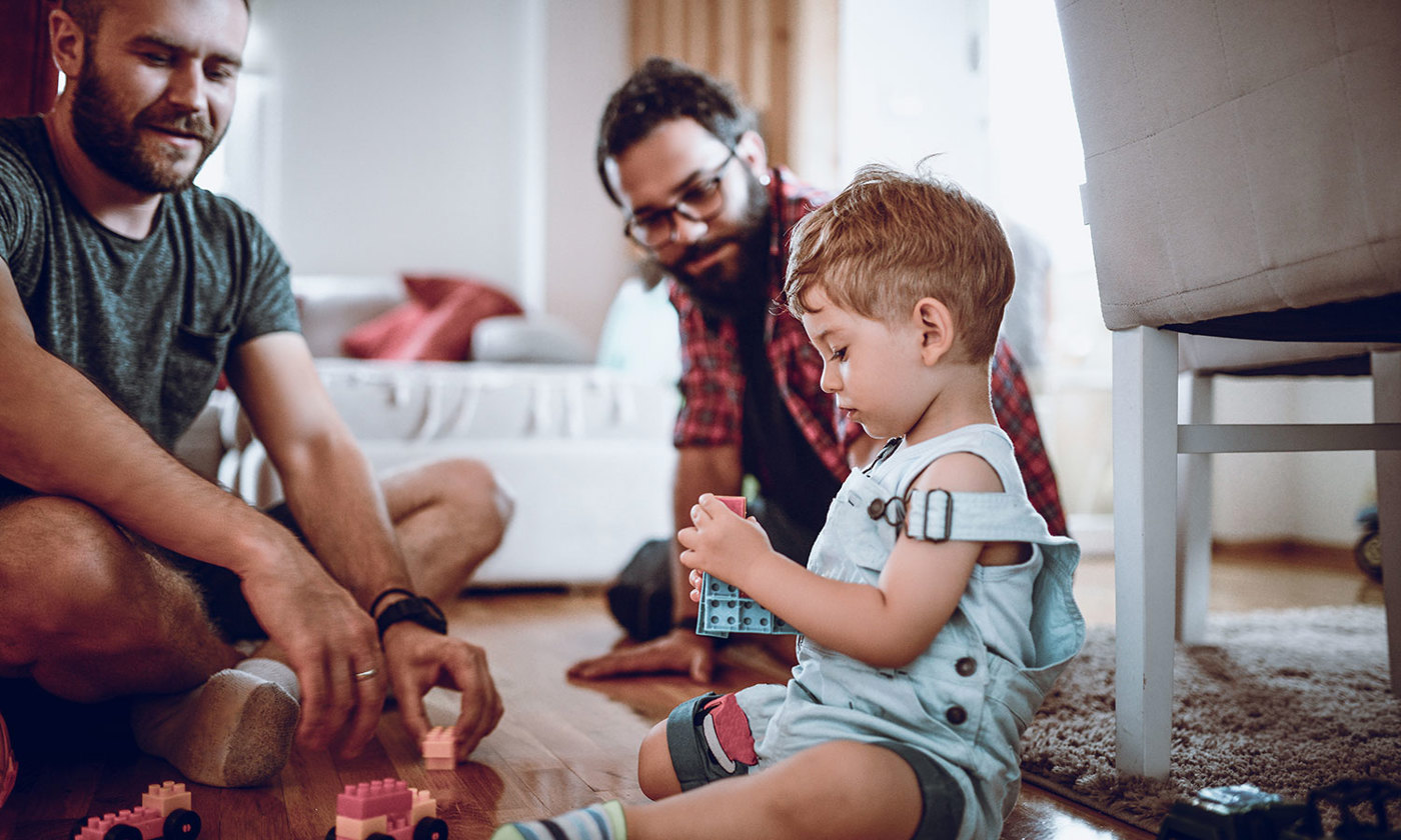 Couple talking with adopted son while he plays