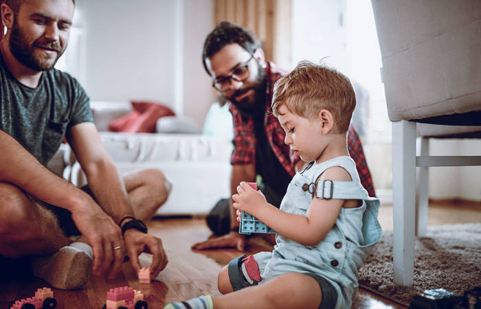 Couple talking with adopted son while he plays