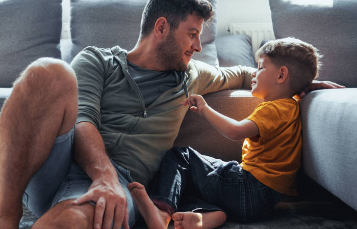 Father and son are spending time in the living room