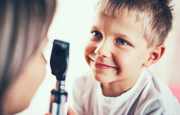 Doctor is examining eyes of the little boy