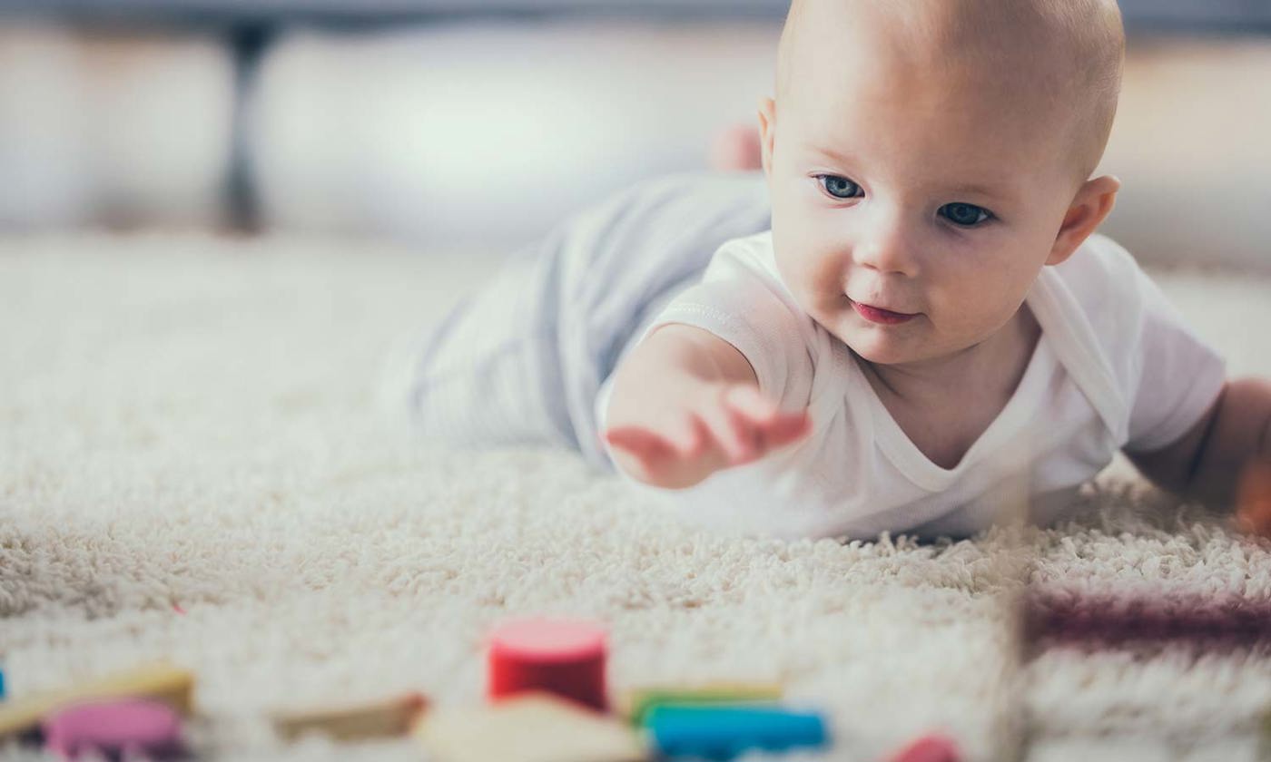 Baby on the floor with coloured blocks