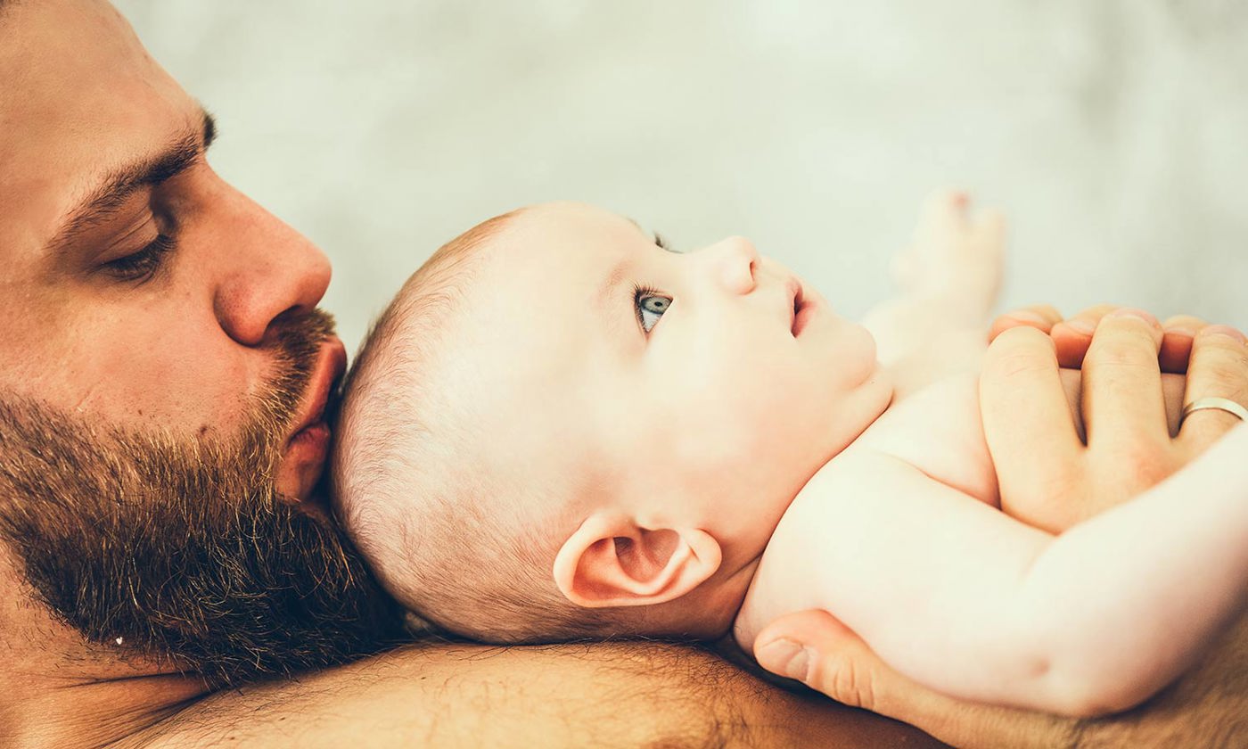 Father holding baby on chest