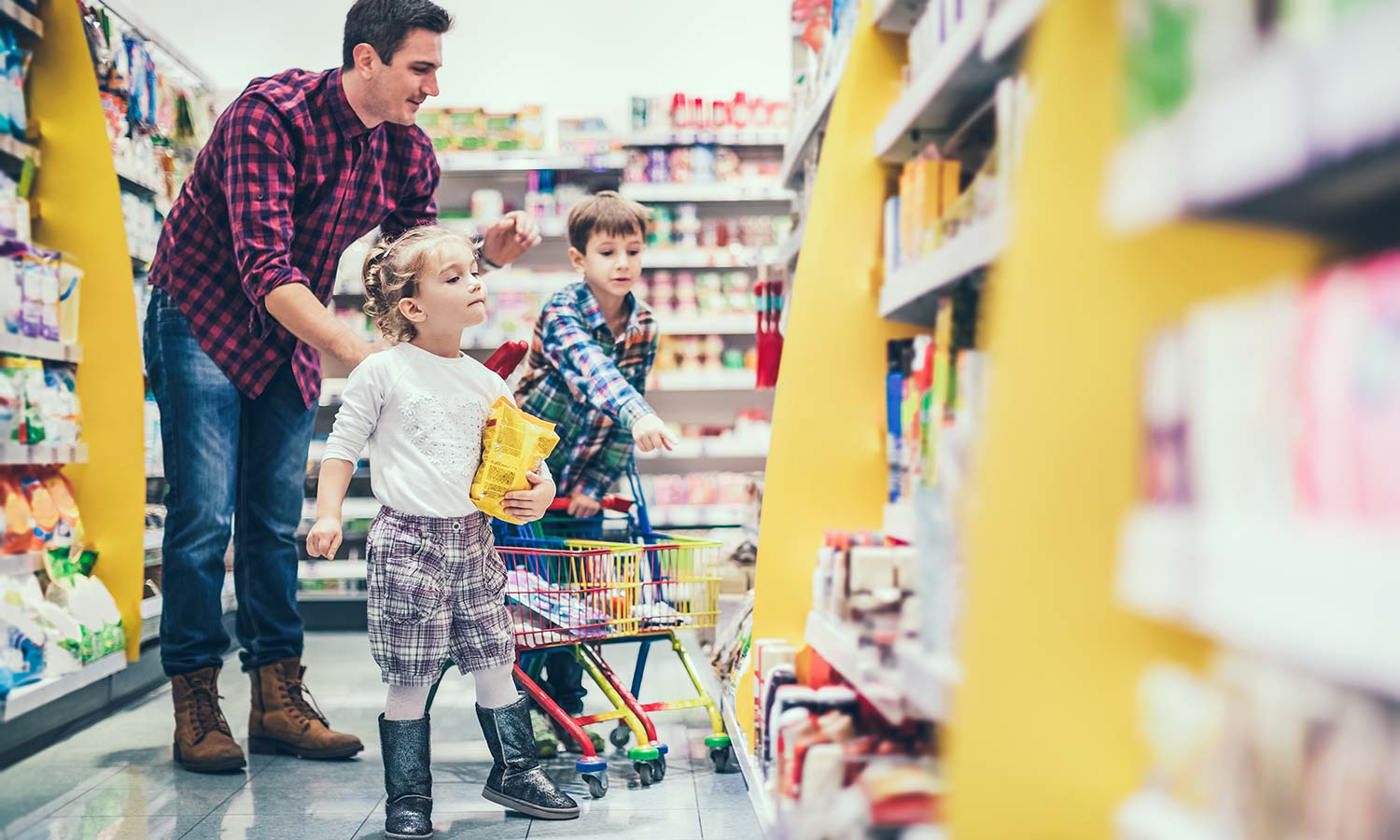 Dad pushing shopping trolley with kids