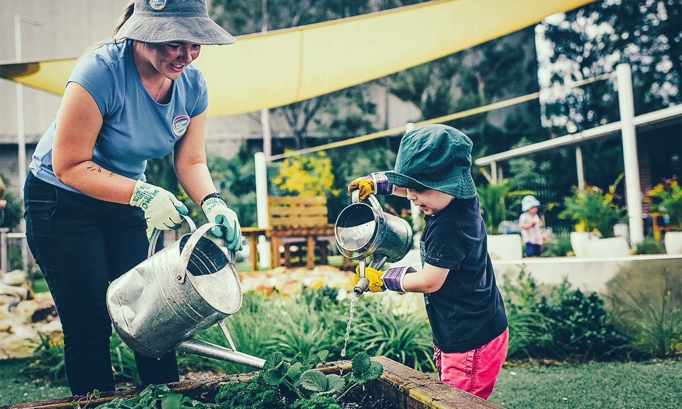 Preschool teacher in garden with child