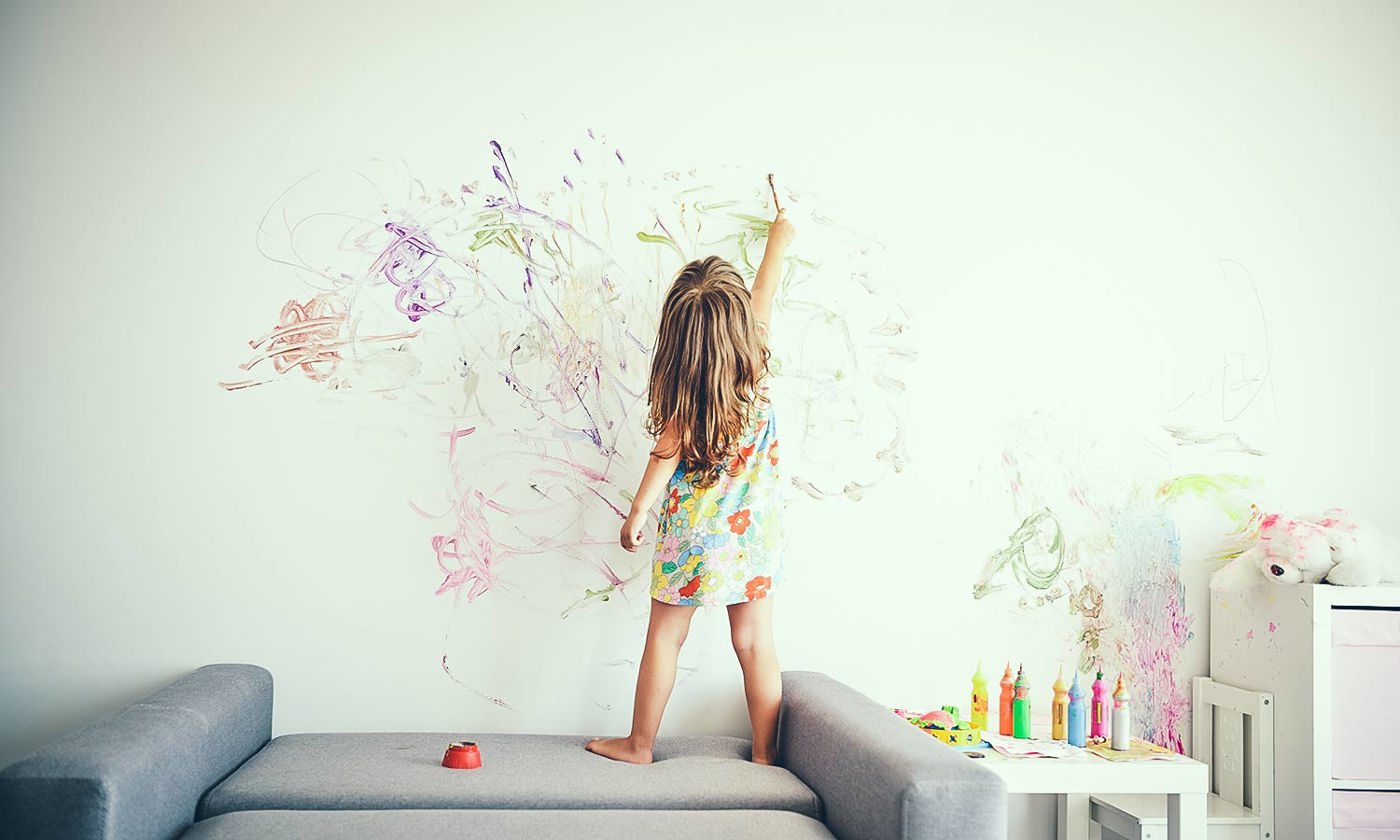 Little girl painting a wall