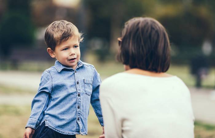 Cute little boy complaining to mother outdoors