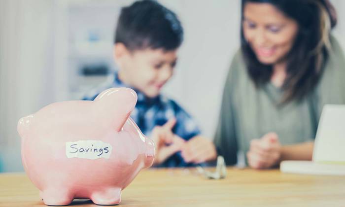 mother and son counting change from piggy bank