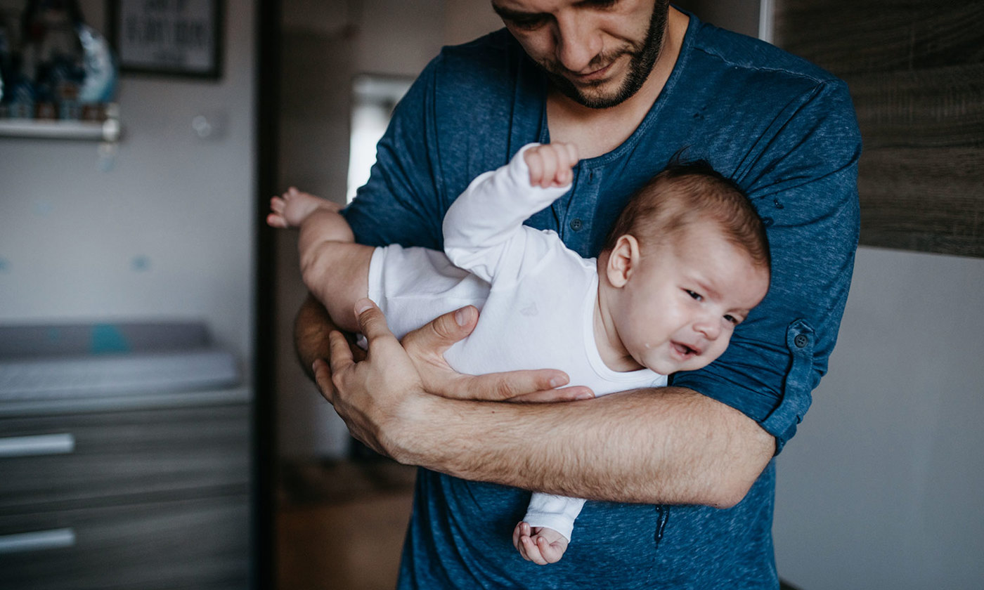 Dad holding crying colic baby