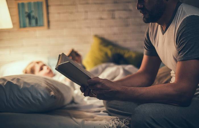 Father reading bedtime story to son