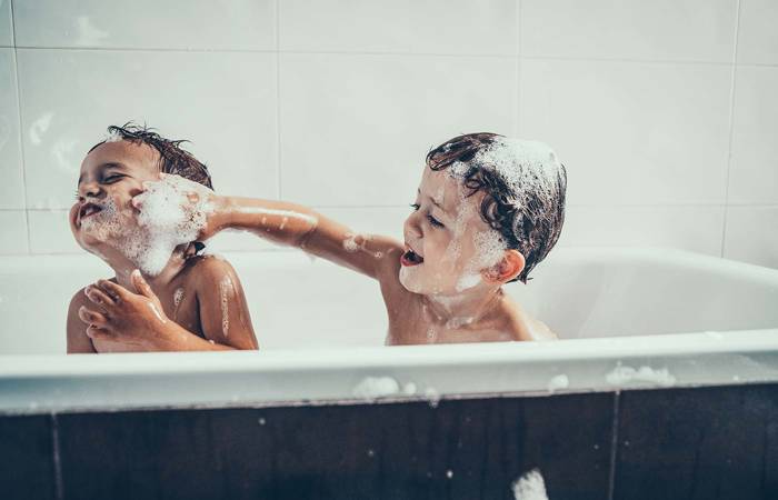Brothers playing in the bathtub