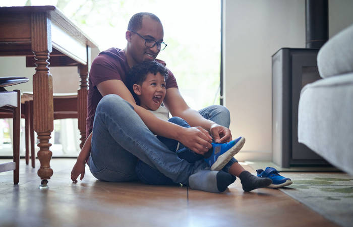 Dad helping tie son's shoes