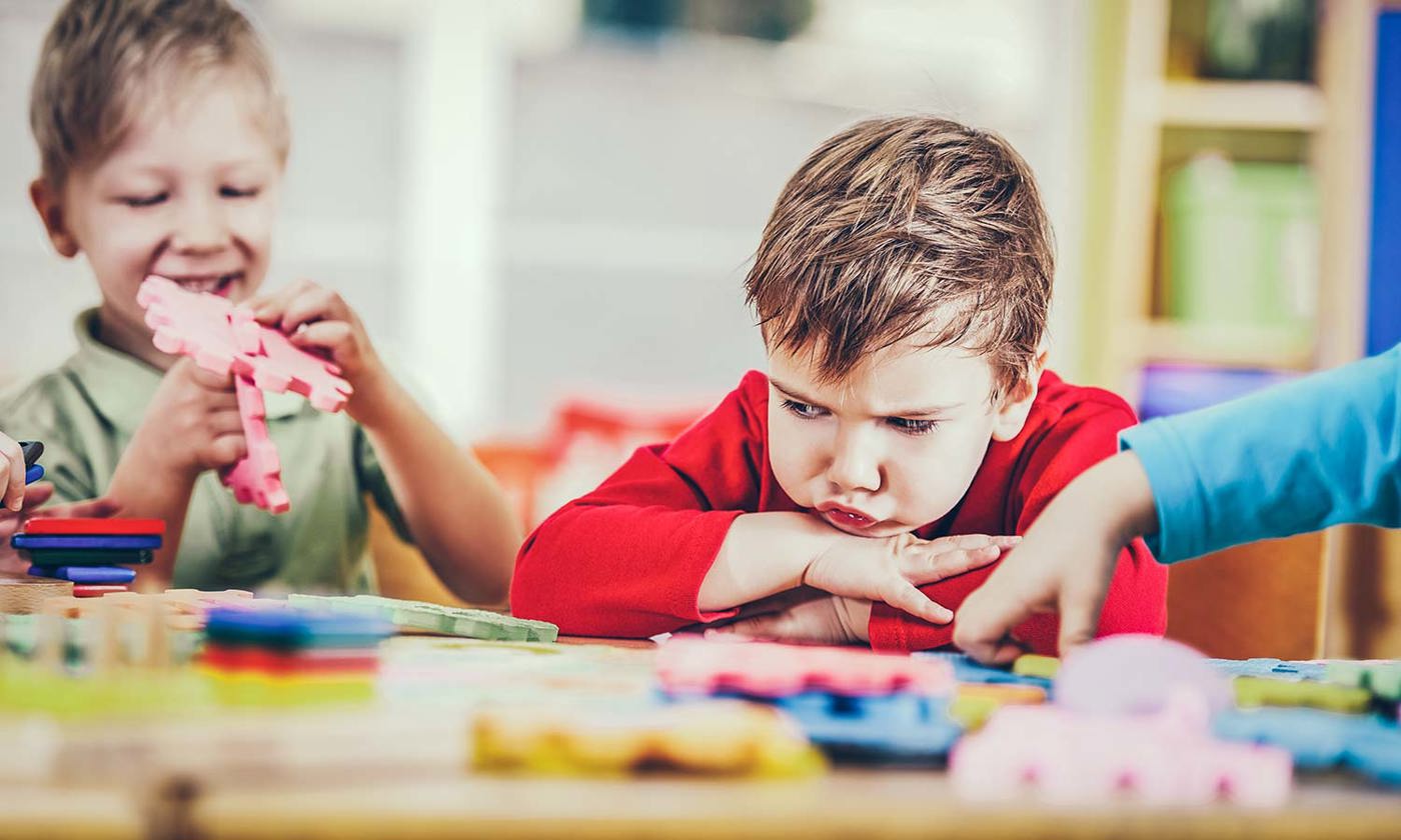 Angry boy looking at puzzles