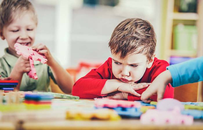 Angry boy looking at puzzles