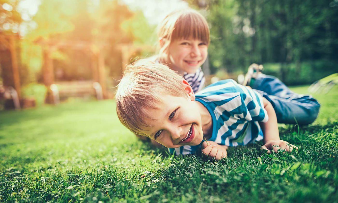 Brother and sister playing on the lawn