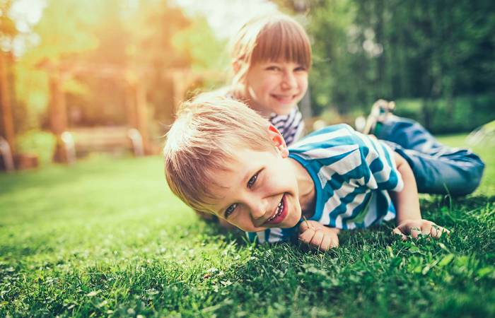 Brother and sister playing on the lawn