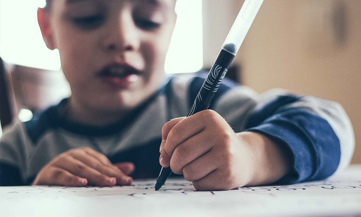 boy writing with a pen