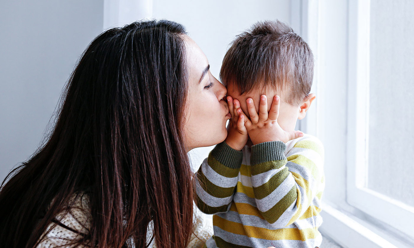 Mother kissing her little son