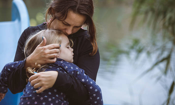 Little girl sleeping in her mother's arms