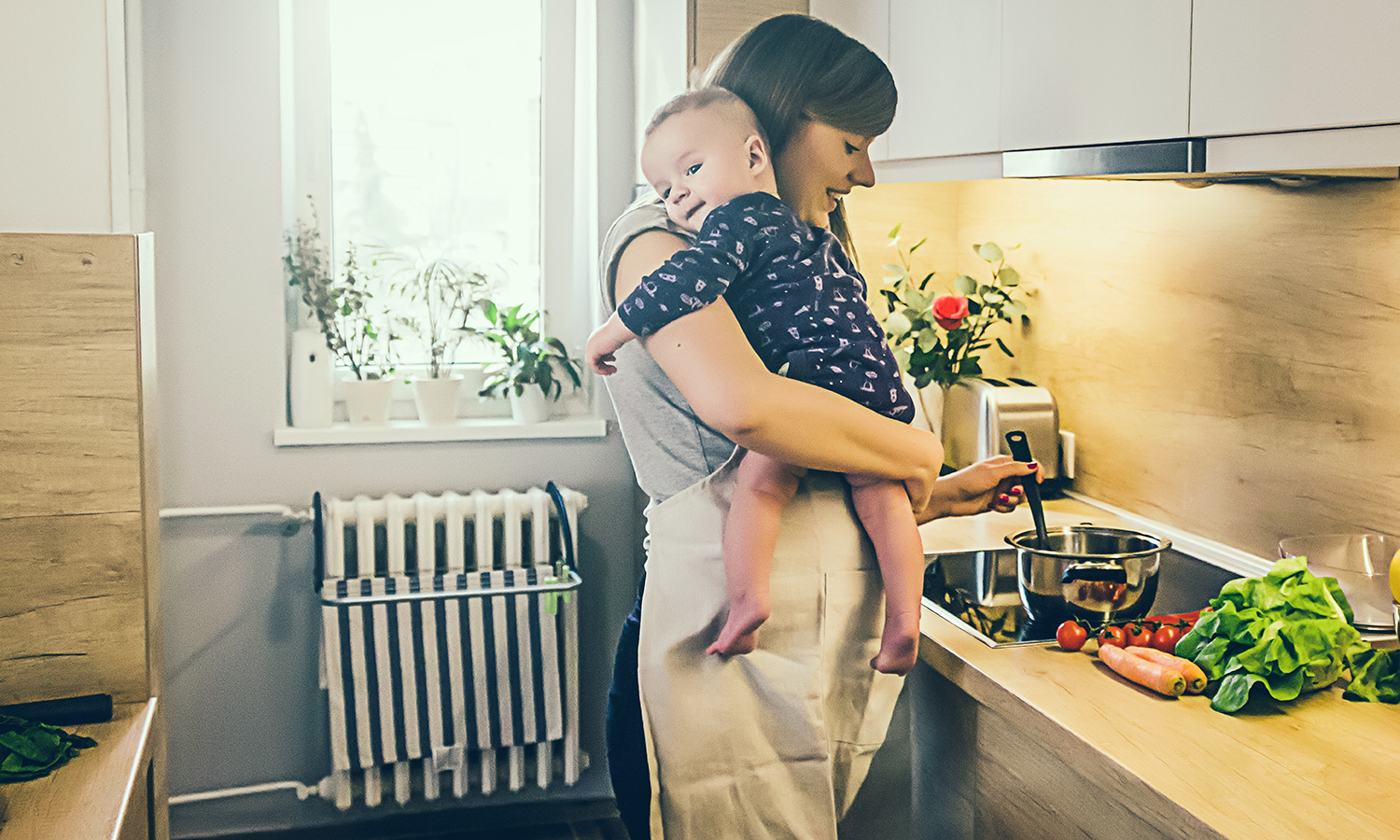 Mum cooking in the kitchen with a baby