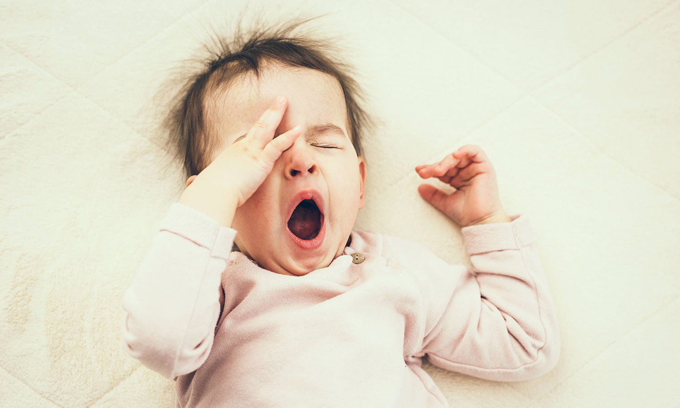 Sleepy baby yawning