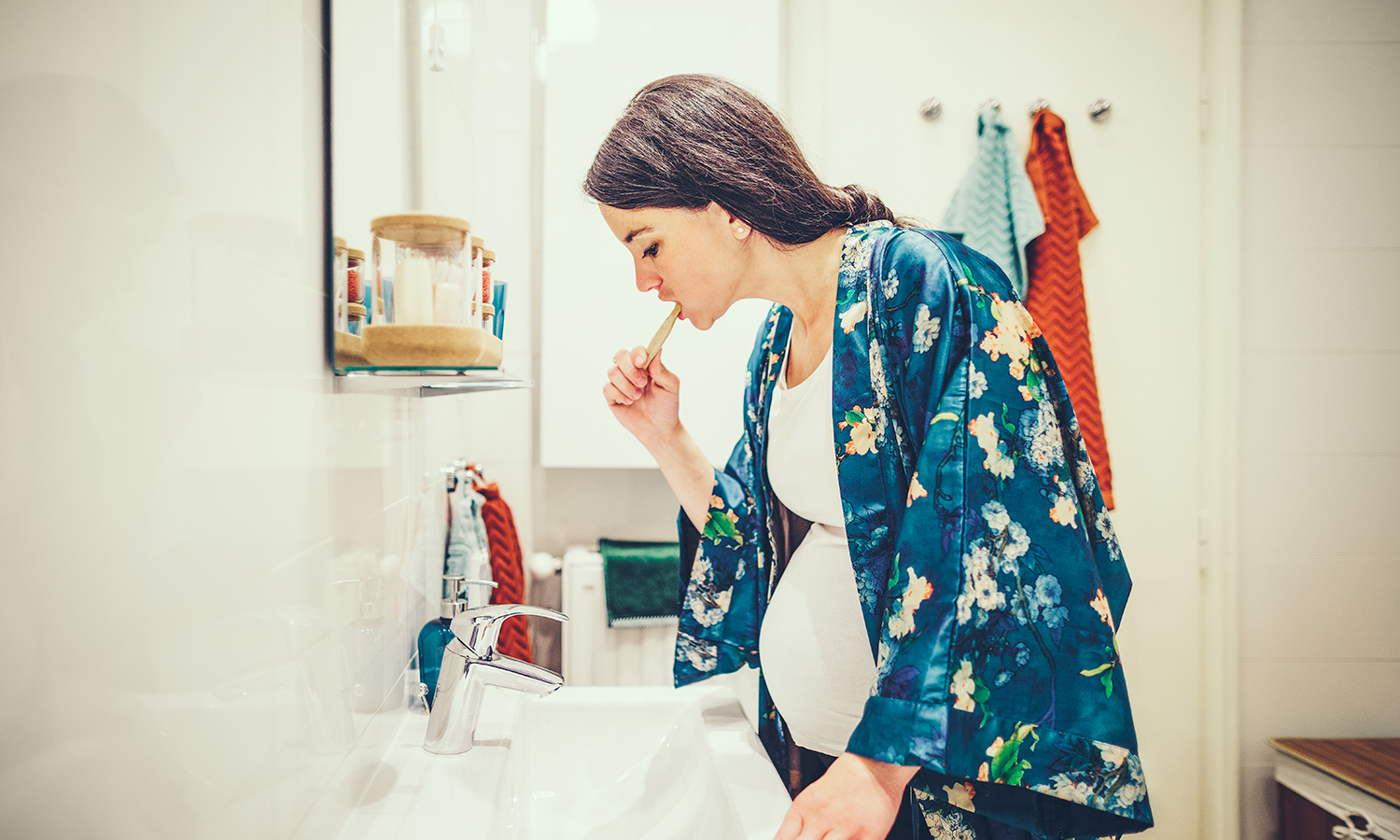 Pregnant woman brushing her teeth