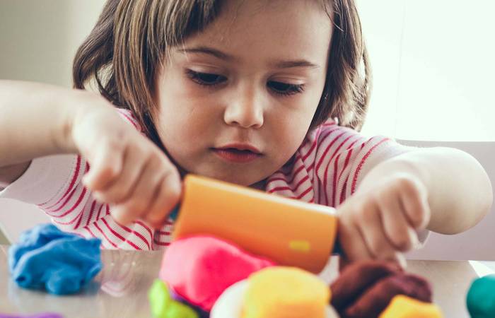 Girl rolling play dough