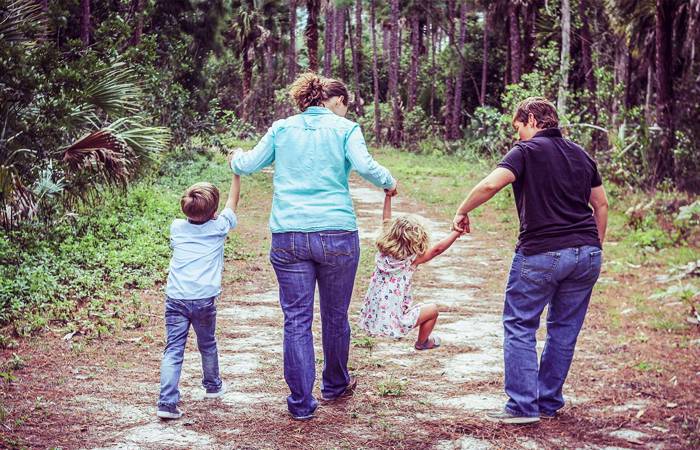 two mums walking on track with their children