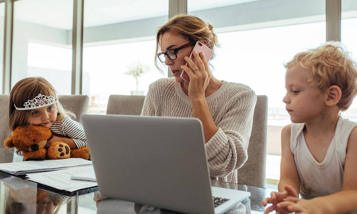 Mother working and looking after two children